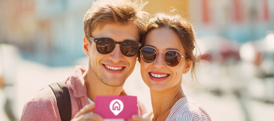 Happy couple in sunglasses enjoying their holiday, smiling in the sun.